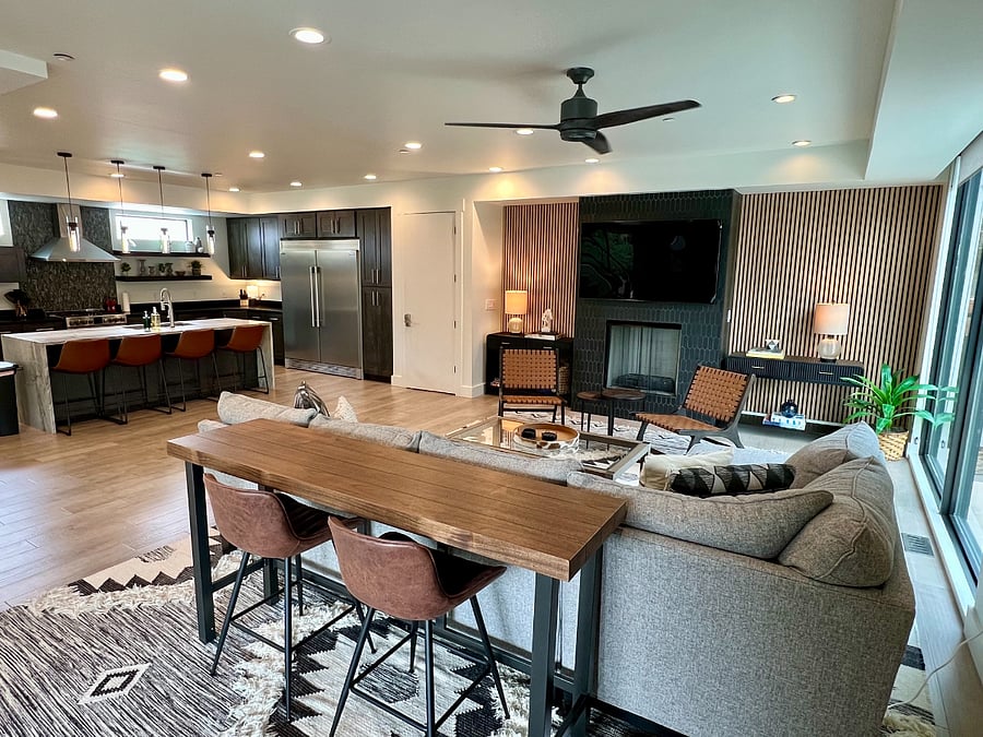 Large open-plan living room with floor to ceiling windows, 75 SmartTV, Ceiling Fan, Sectional Sofa, Console desk for eating and watching tv or working.