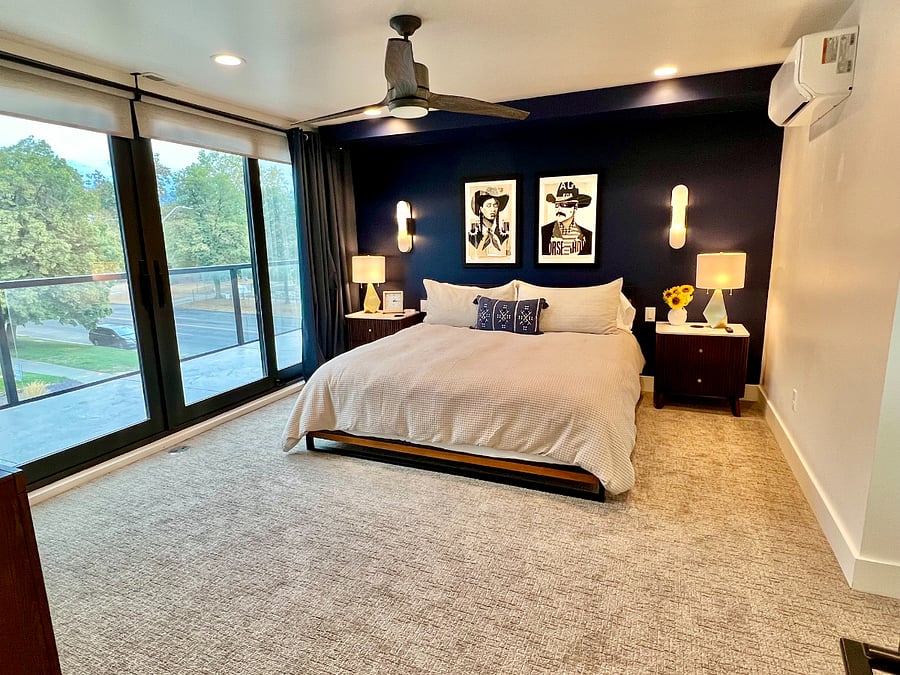 Large primary bedroom with king size bed, 65 TV, dresser, wrap around balcony, floor to ceiling windows with blackout curtains and a huge walk-in closet.