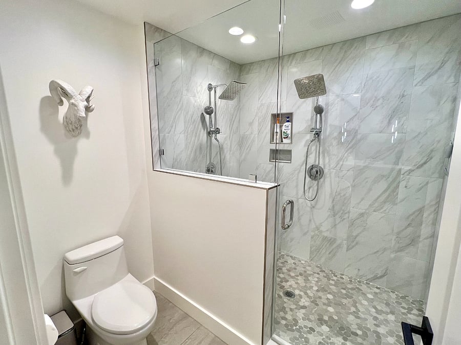 Huge marble walk in shower with dual shower heads.