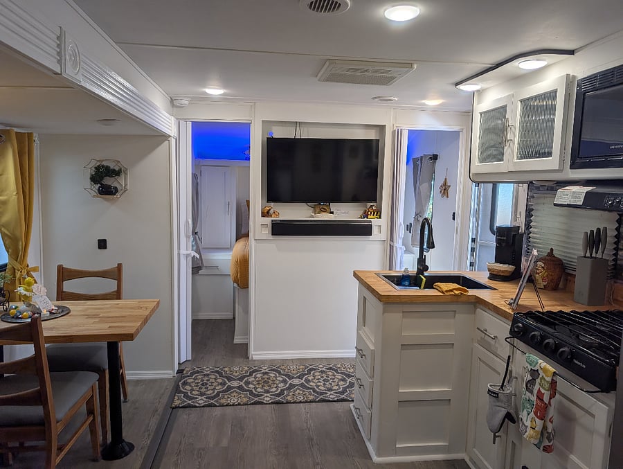 The RVs main living space is very comfortable, with plenty of natural and ambient lighting, a TV for entertainment, and air conditioning throughout to keep the space cool and enjoyable.