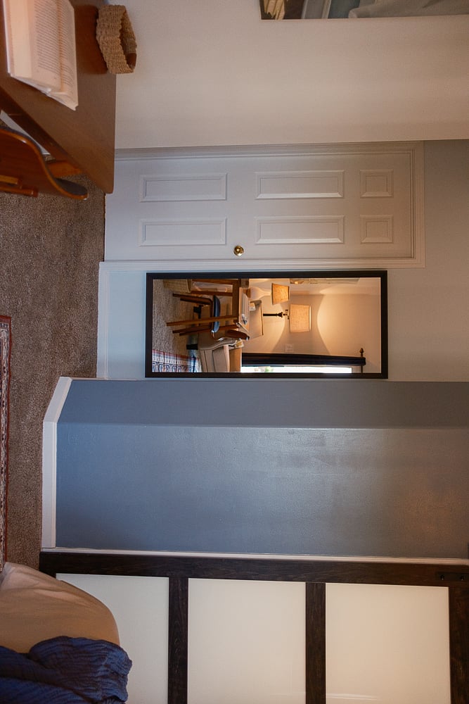 Full-length mirror and barn door into the private bathroom