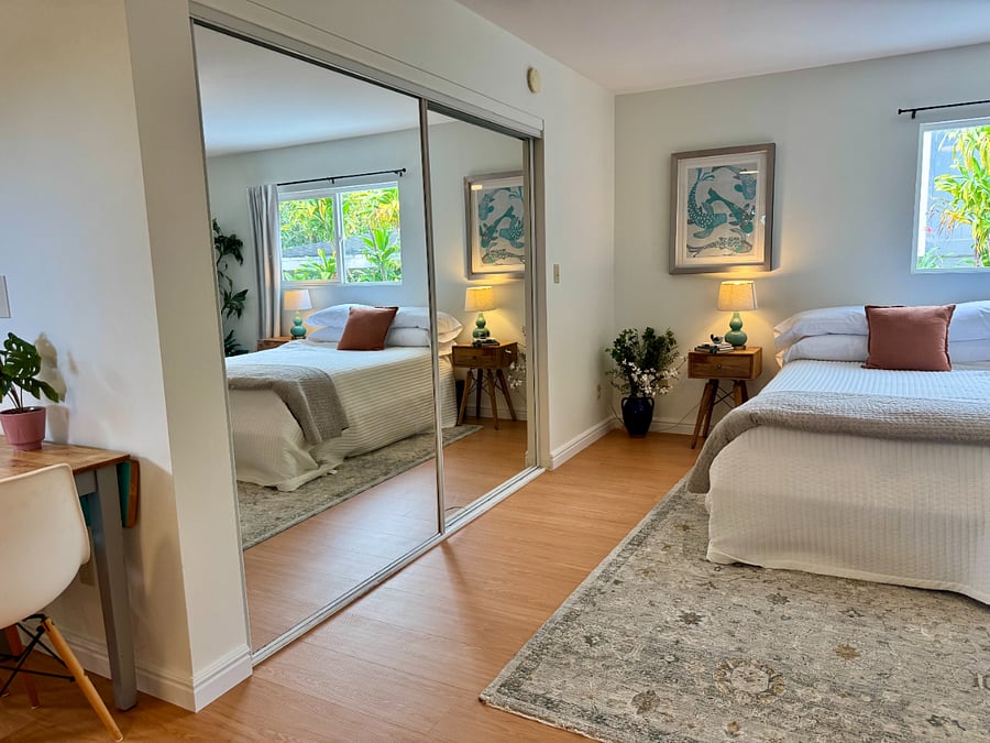 Full mirrored closet wall and dual nightstands with reading lamps. Plenty of space for a 30-day unpack.