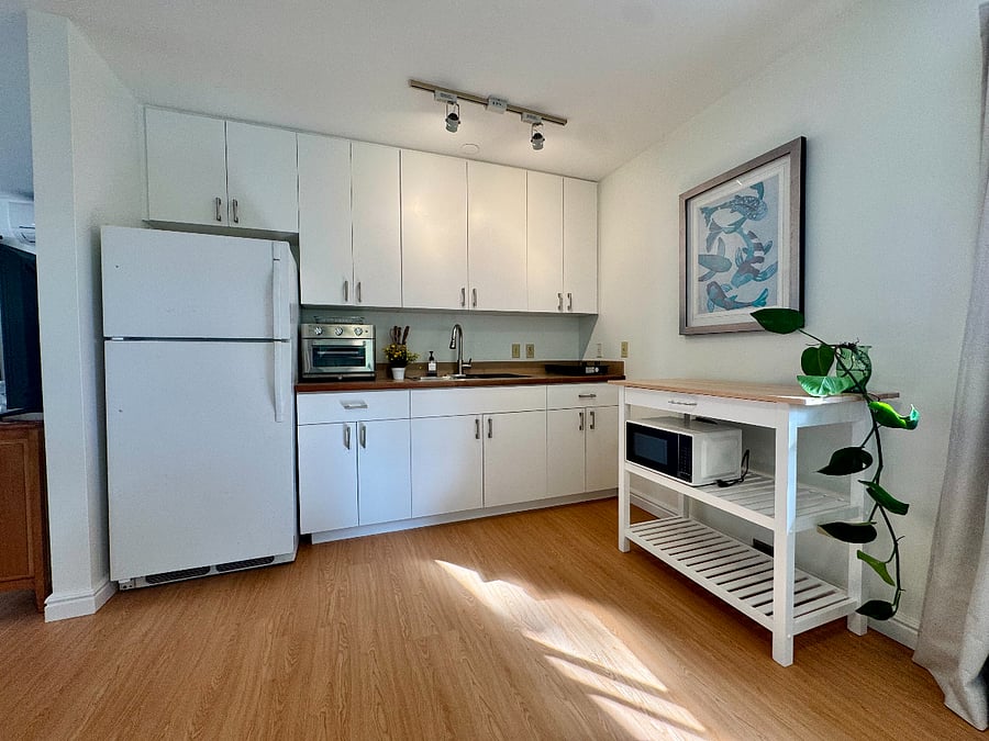 Full-size refrigerator, microwave, drip coffee maker, and induction cookware all included. Real kitchen for real cooking.