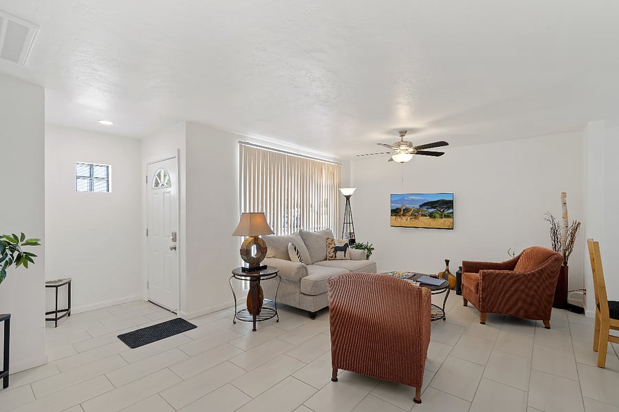 Roomy Living room at entry with Roku smart TV, great seating, uncluttered, with ceiling fan. 