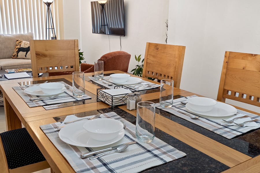 Gorgeous dining table in dining room connected to the kitchen. Dishes and utensils for adults and children provided