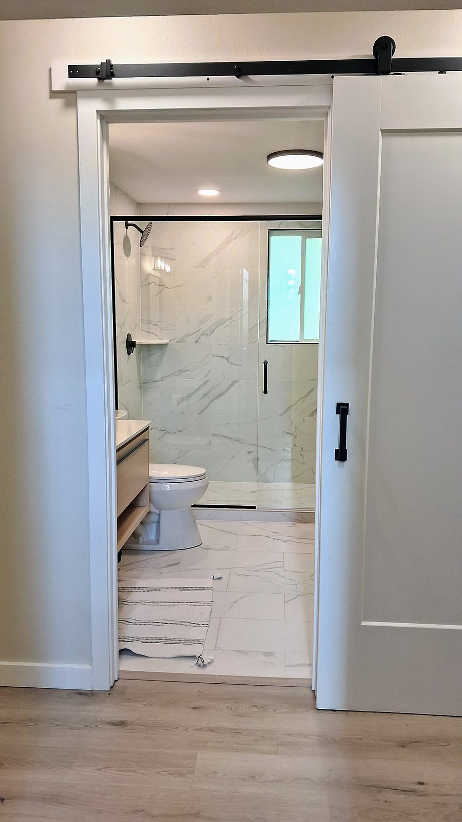 fully renovated bathroom with stylish barn door