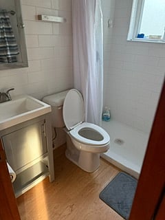 bathroom, built in storage and shelving to right of the shower (not pictured in this photo)