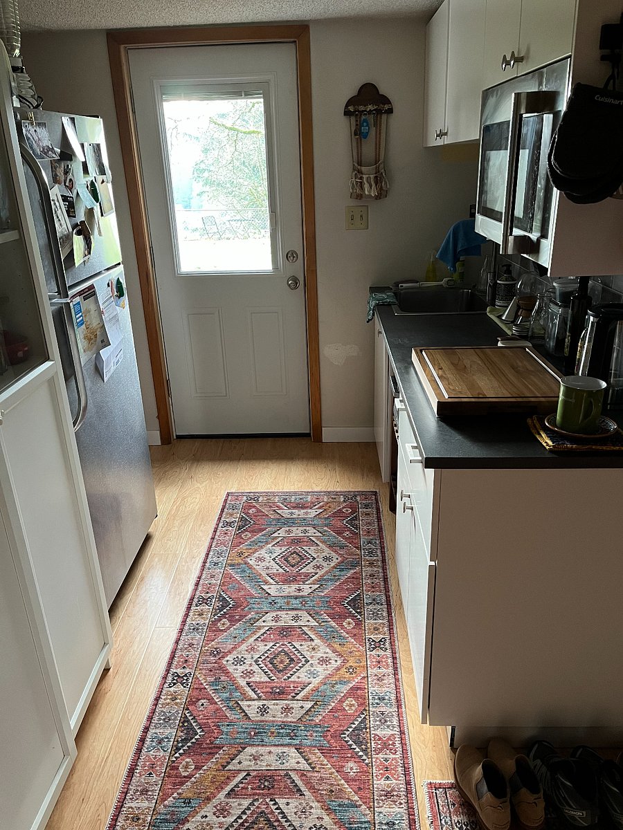 Galley kitchen with fridge on left and microwave on right