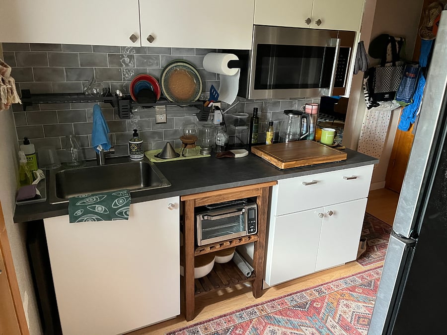Different view of kitchen with dish racks, etc