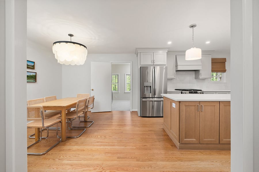 Six person dining table in the large kitchen area. The door straight back leads to the laundry/mudroom and back door.