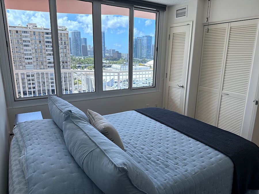 Serene bedroom with city and ocean views.