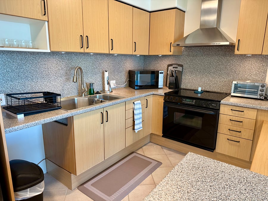 Modern kitchen and fully stocked cabinets (dishes, cookware, cutlery) ready for use.