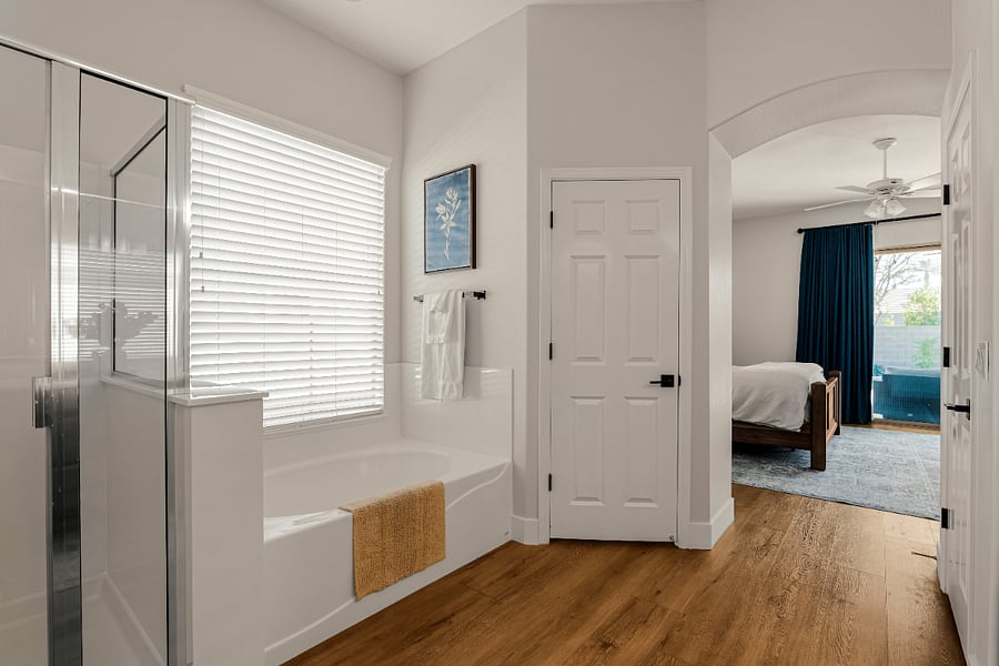 Primary Suite bathroom - with deep soaking tub, glass-enclosed walk-in shower, and dual vanities with natural light.