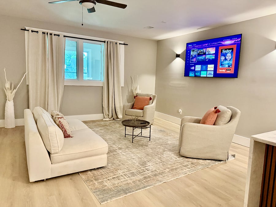 Wall-mounted TV, soft seating, and natural light  the kind of common space that makes a house feel like home.