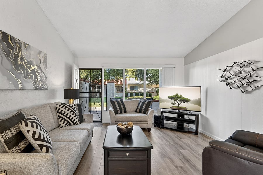 Cozy living room with a comfortable couch and large TVperfect for relaxing after a long day. Enjoy beautiful views of the patio and courtyard overlooking the golf course fairway. Includes a power-lift recliner for added comfort and ease.