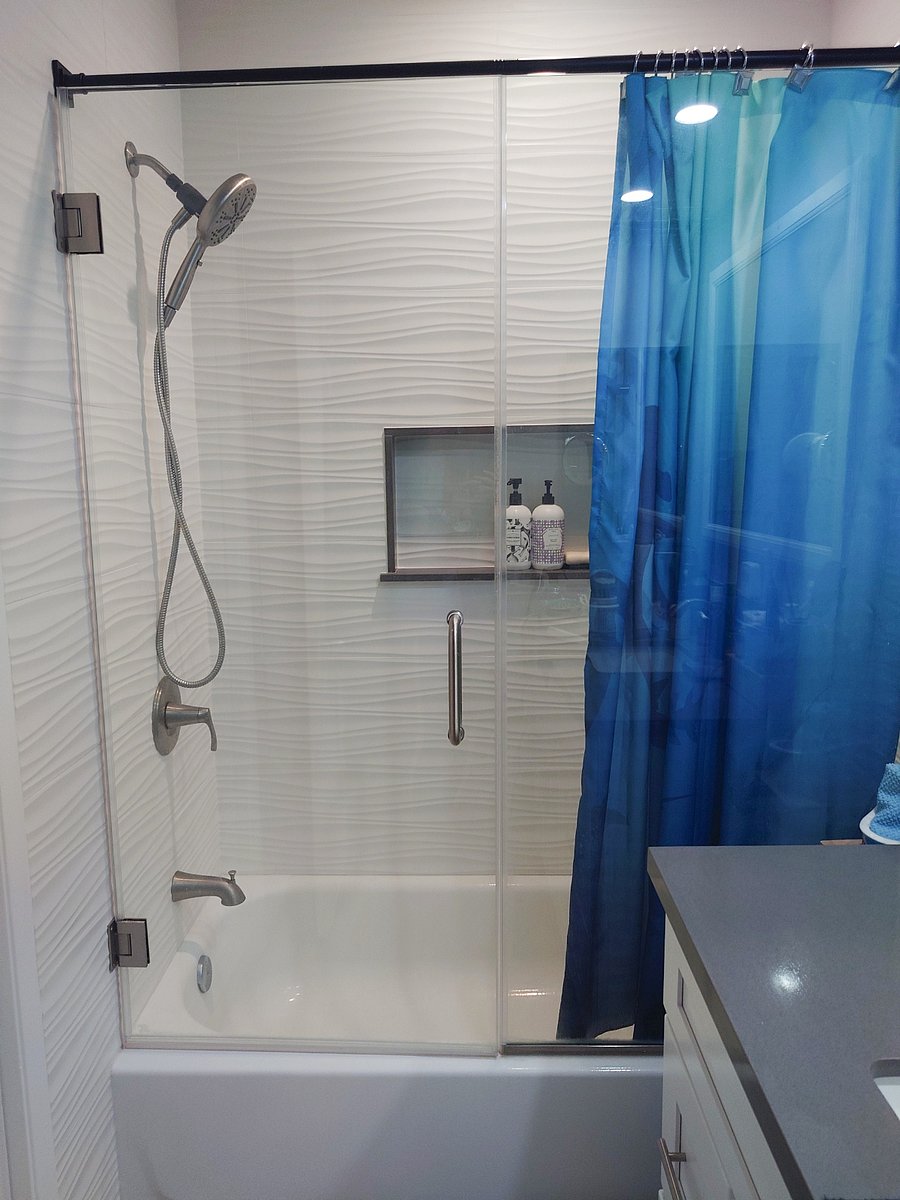 Bathtub with shower in upstairs bathroom.