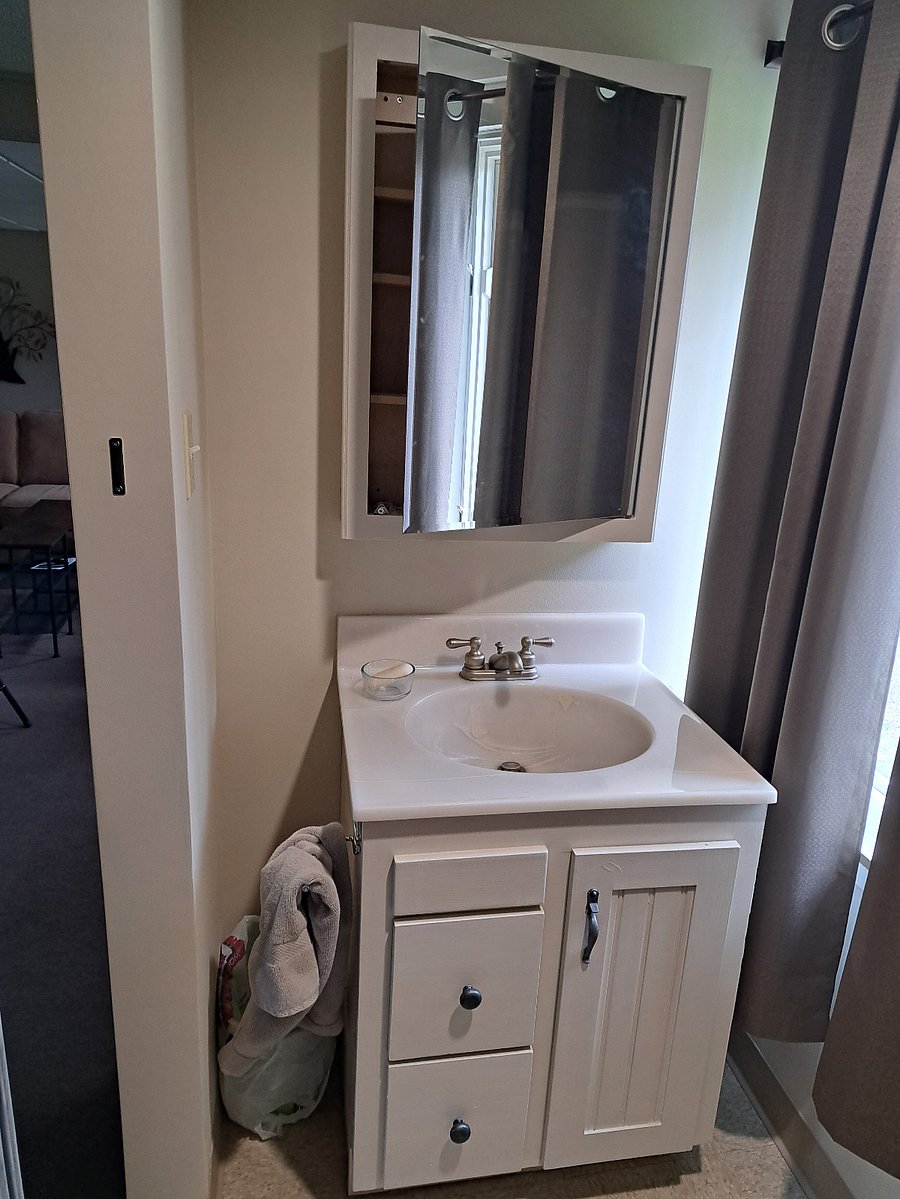 Private 1/2 bath with wall mirror storage shelves and vanity