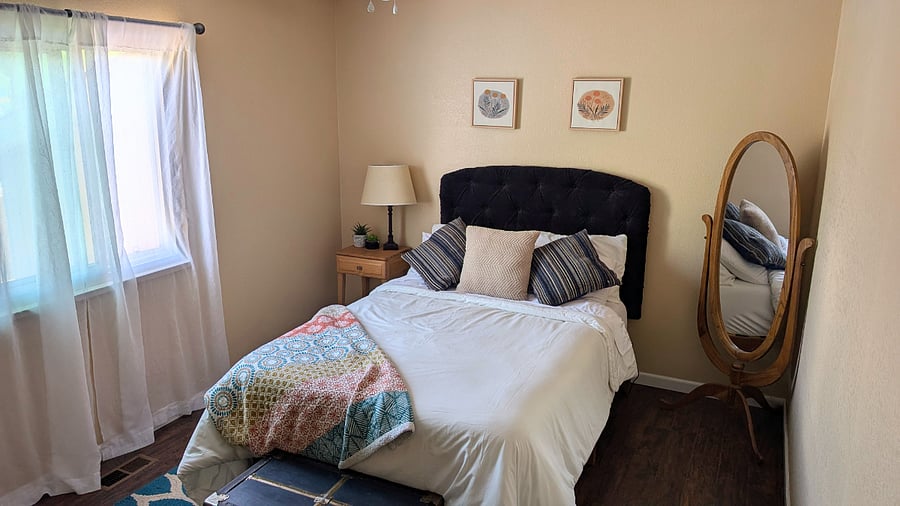 Bedroom #2 upstairs with full bed, full mirror, and bedside table and lamp. 