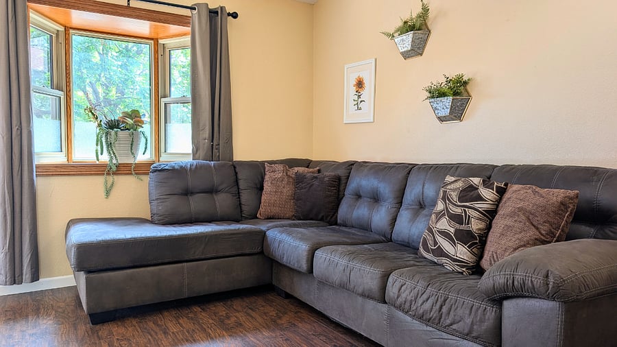 Living room #1 with cozy sectional couch and bay window.
