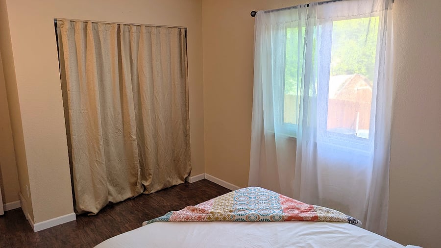 Bedroom #2 upstairs with window overlooking side yard. 