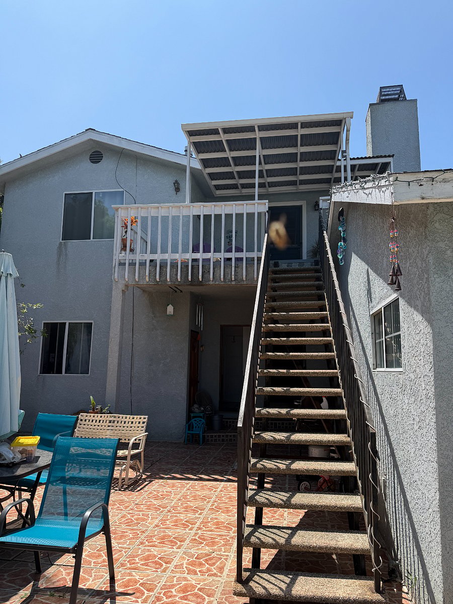 Looking up flight of stairs to balcony and front door