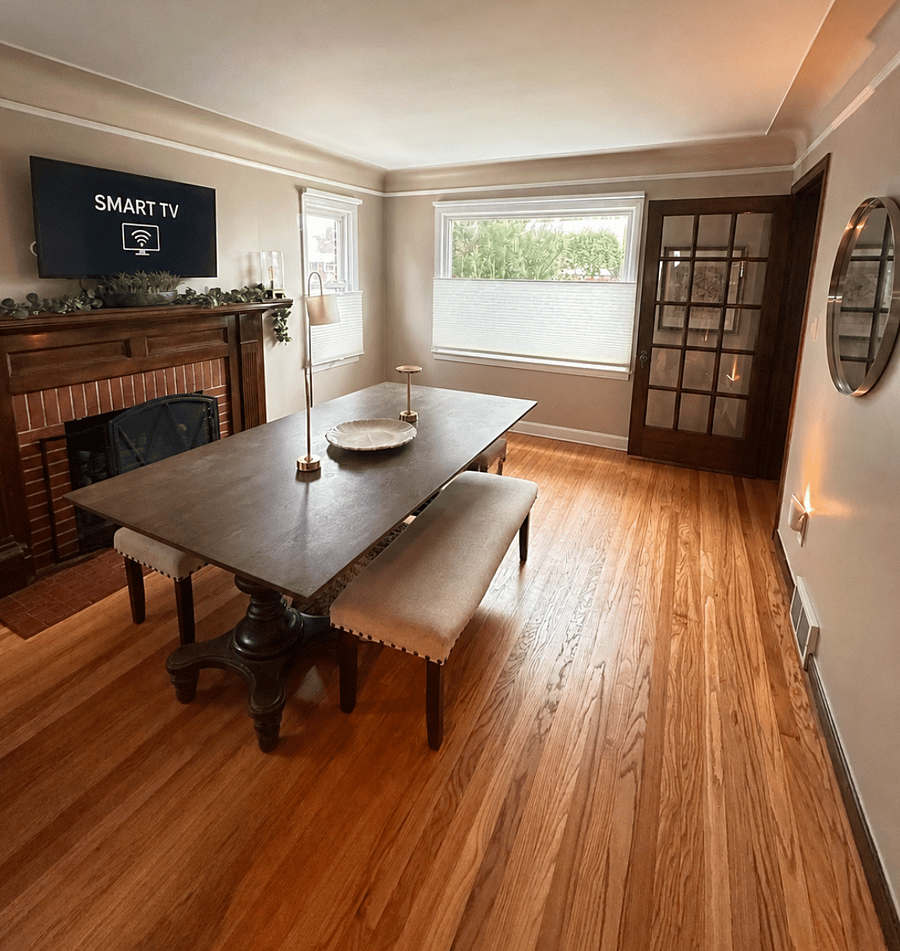 Spacious front room with large library table, fireplace, and SmartTV