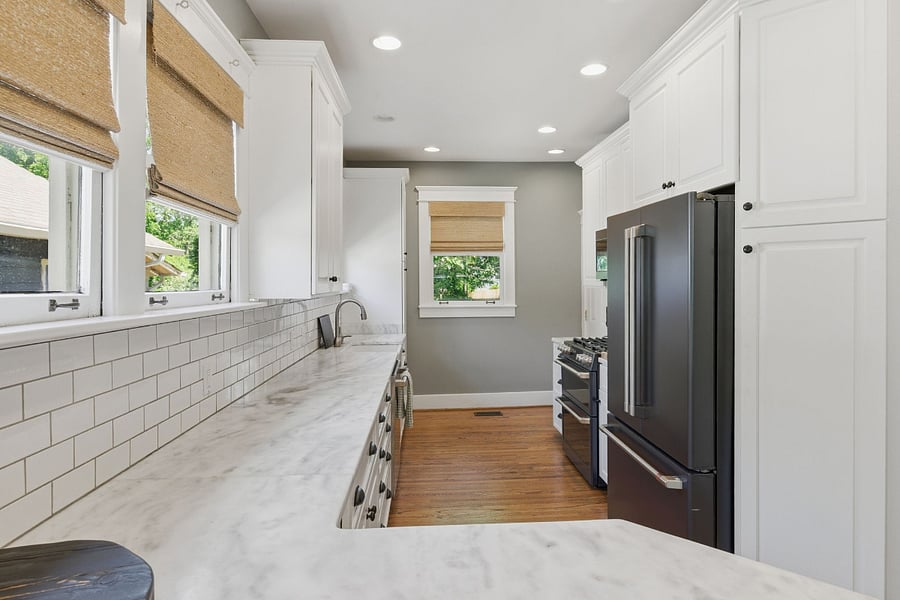 GE Caf appliances in matte black with a gas stove and marble counters  chef's kitchen ready