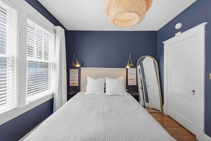 Primary bedroom with queen bed, abundant windows, and natural light pouring in or use the Pottery Barn blackout curtains for the perfect sleep environment.