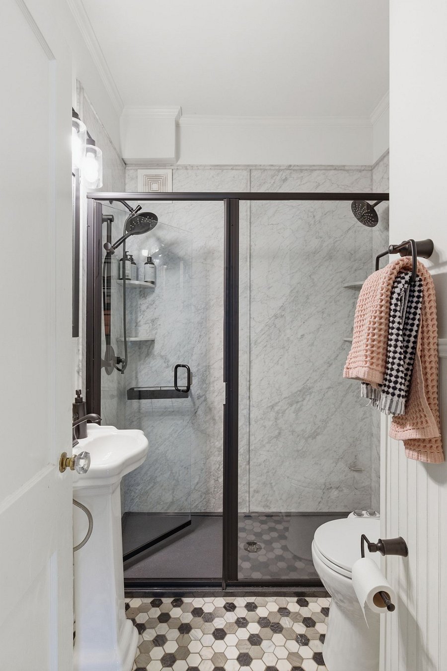 Bathroom located on main floor. Newly updated primary bathroom with marble floors, natural stone walls, and dual shower heads. Deep linen closet and zero-entry shower for luxury and ease