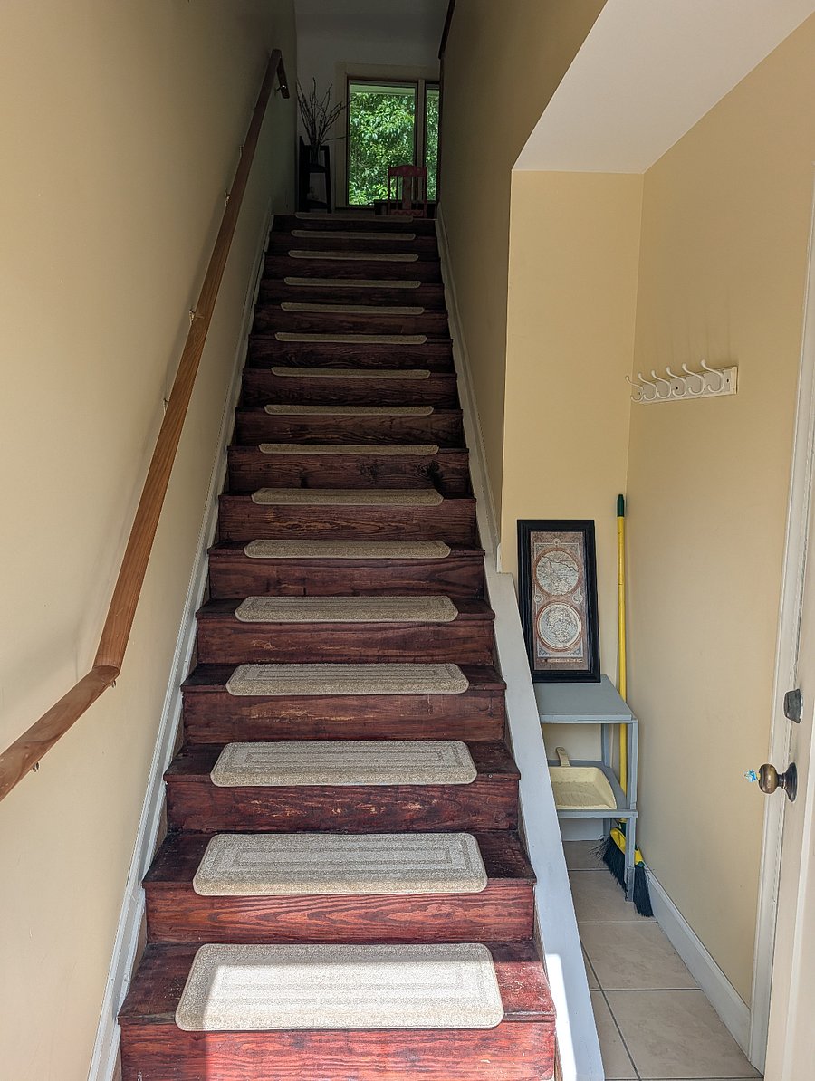 Stairwell from front entrance. Main living space is upstairs. Flex space and second bedroom and half bath are to the right
