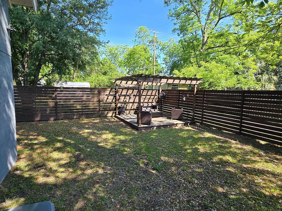 Fenced backyard with pergola