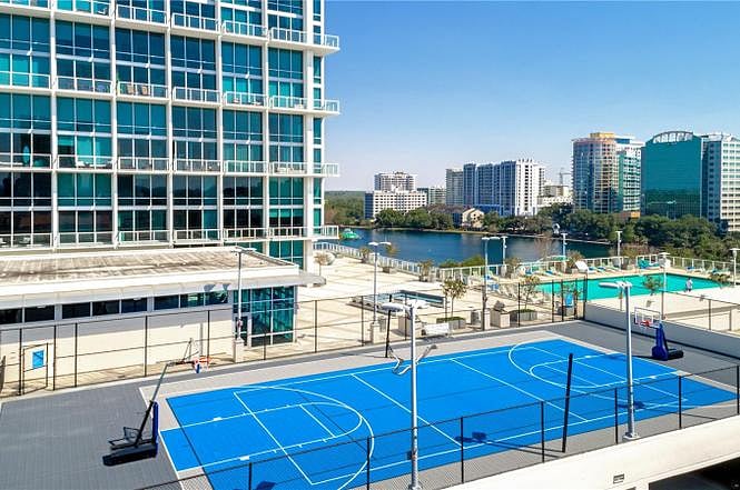 Full size tennis court with basketball hoops