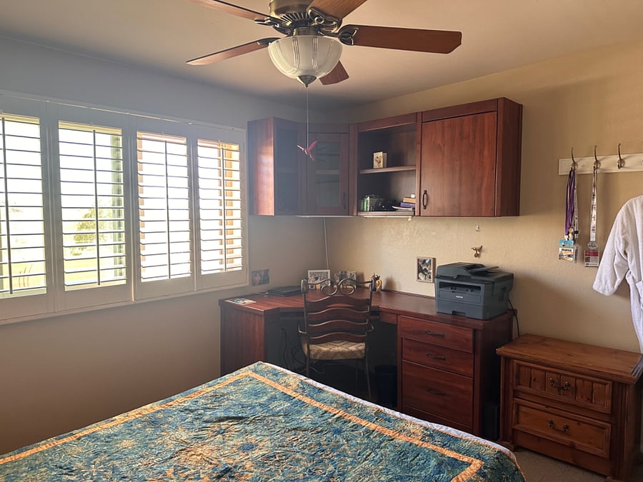 Guest bedroom has built-in desk and wall cabinets