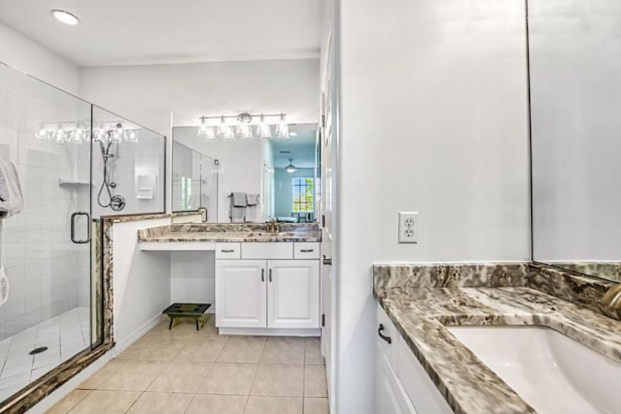 Master bath with separate vanities and large walk in shower and closet