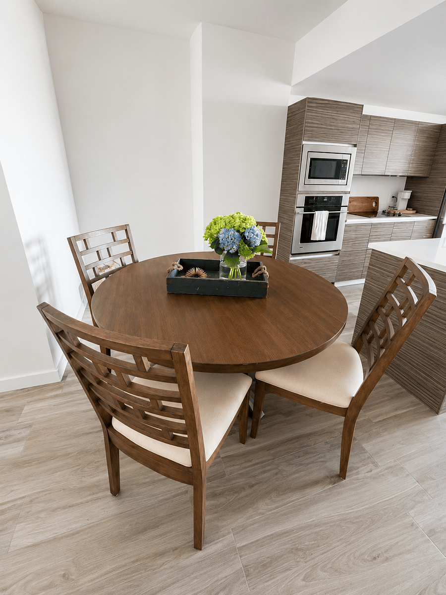 Elegant dining area with seating for four, enjoy beautiful water views and natural light. Perfect for intimate dinners, morning coffee, or gathering with family and friends in a refined, welcoming setting.