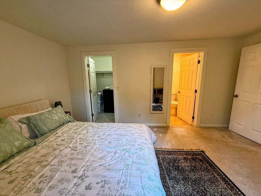 Primary bedroom access to ensuite and walk-in closet with dresser