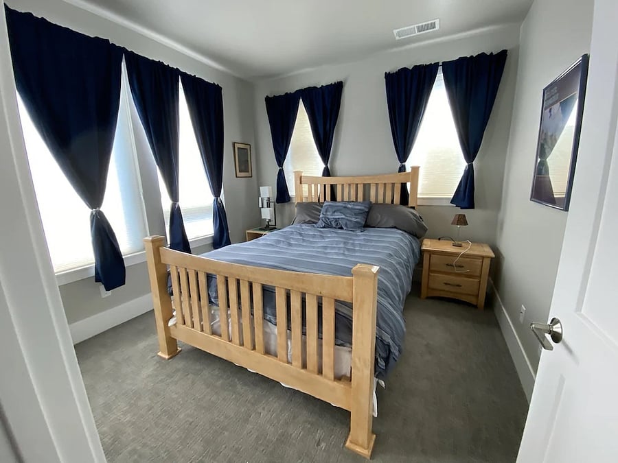 Second (guest) bedroom with queen bed and blackout curtains.