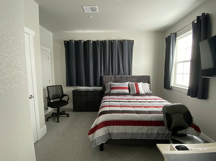 1st floor bedroom with queen bed, desk, 50" TV.
