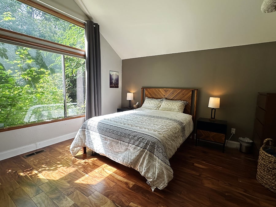 Main floor master with large forest facing window.
