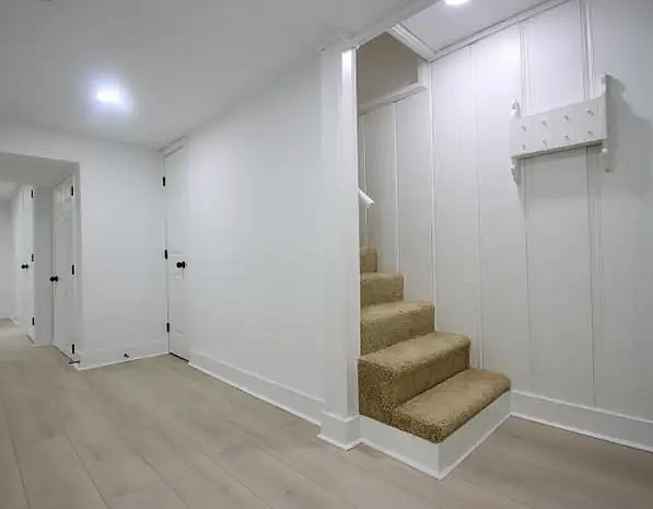 Stairway leading to main level of house with shared dishwasher and shared full kitchen. 