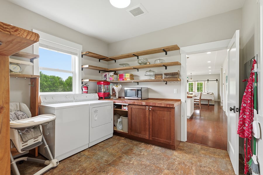 Mudroom fully stocked with ample storage, full size washer and dryer, durable flooring, outdoor towels, and more.