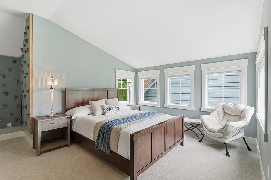 Bedroom two with queen bed, walk in closet, dresser, smart TV, wood blinds, and ample space