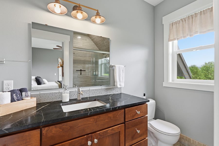 Master shower with premium glass doors and double shower heads.