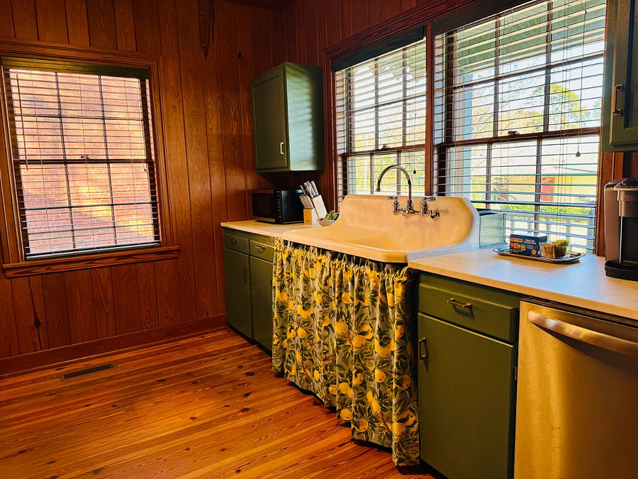 The kitchen looks out onto the front porch and green space. An antique cast iron sink and pine walls and floors are complemented by new appliances including full refrigerator, dishwasher, Keurig coffee maker, stove, microwave, and toaster. We provide cookware, dishes, and glassware.