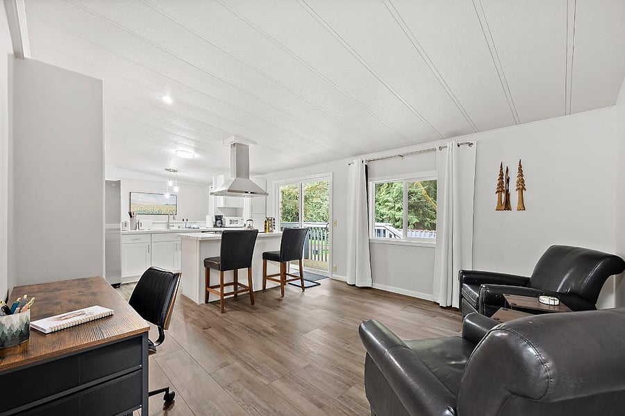 Family room and desk with rolling desk chair located off the kitchen.
