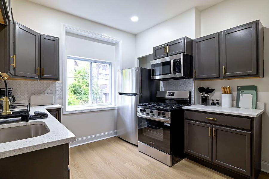 Kitchen with stove, cabinets, microwave, and fridge.