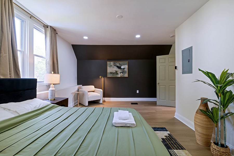 Bedroom with queen size bed and accent chair.
