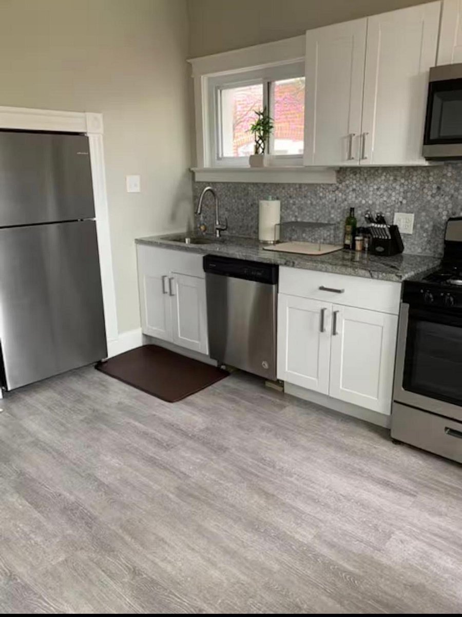 Kitchen with dishwasher, full-size refrigerator and gas stove.