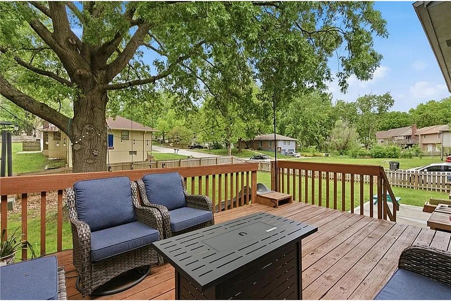 Peaceful backyard deck surrounded by mature trees and open green space, creating the perfect setting to unwind and enjoy the outdoors.