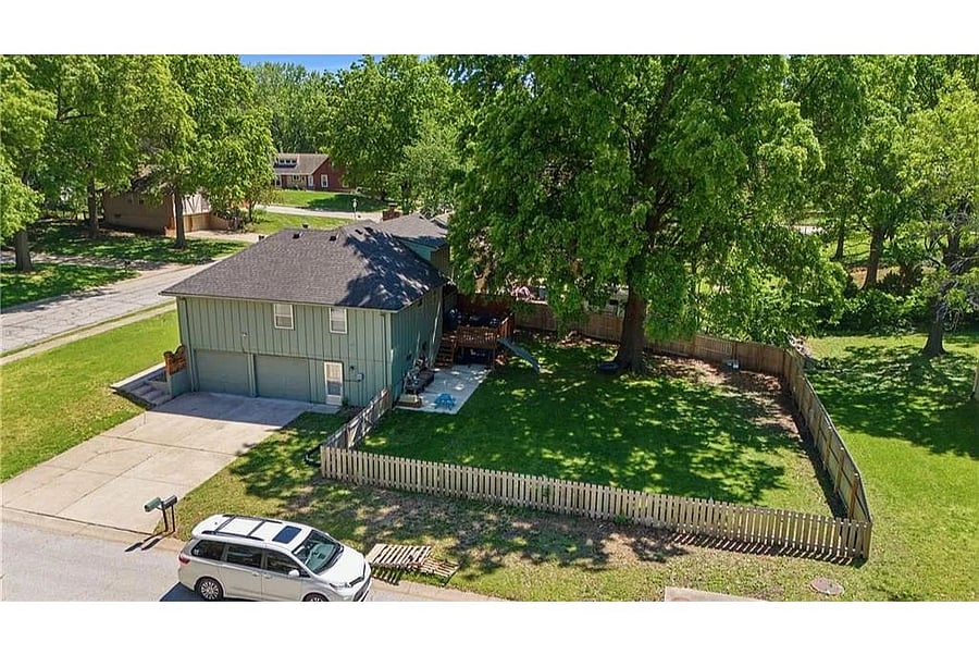Aerial view highlighting the propertys oversized lot, mature trees, and private outdoor space ideal for relaxing or entertaining.